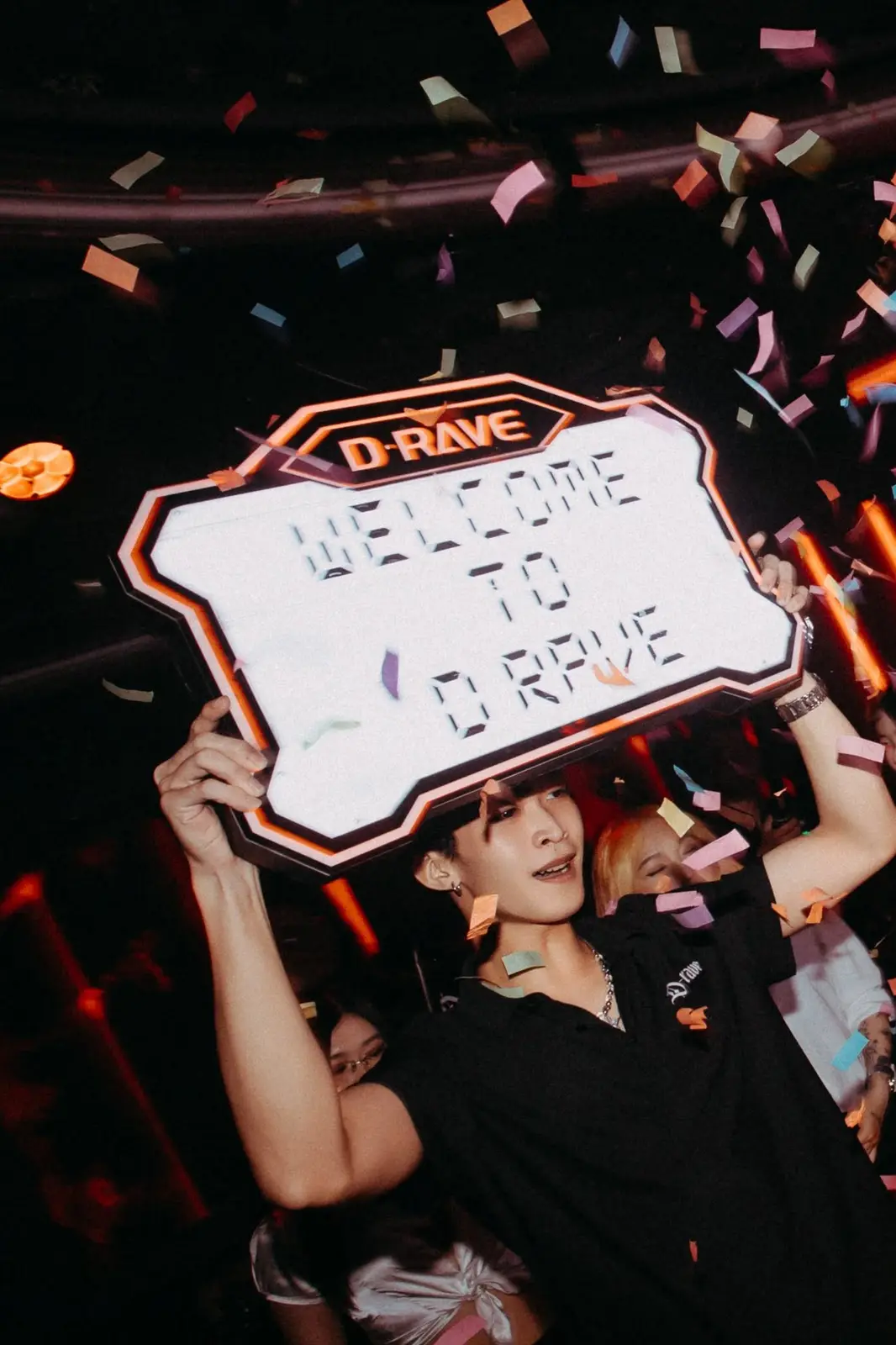 Khách giơ tấm bảng Welcome to D·RAVE giữa mưa pháo giấy tại Drave Club